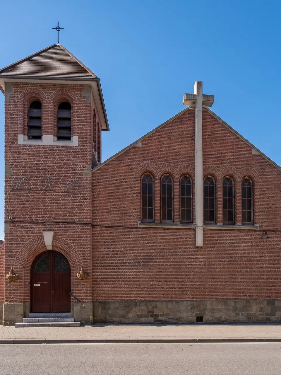 La façade en brique et le clocher de l'église, rue de l'Orient